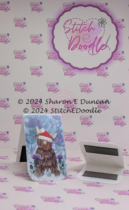 Highland Cow in Santa Hat with Thistles Double sided Laminated Magnetic Bookmark.  Original digital painting by Sharon Duncan.